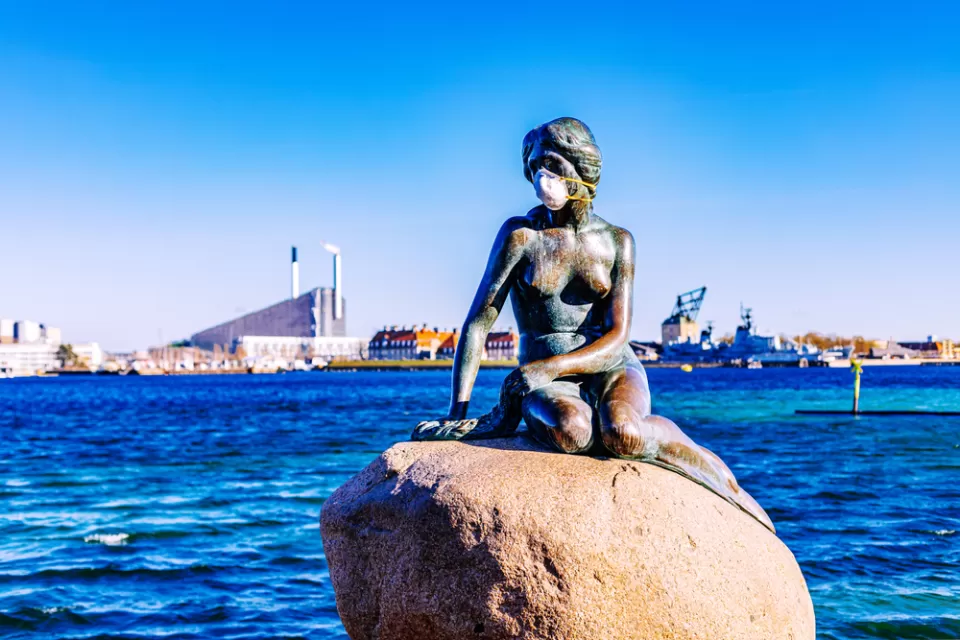 A statue of the Little Mermaid, overlooking the waterfront of Copenhagen, Denmark, is adorned with a mask during the Covid-19 pandemic.